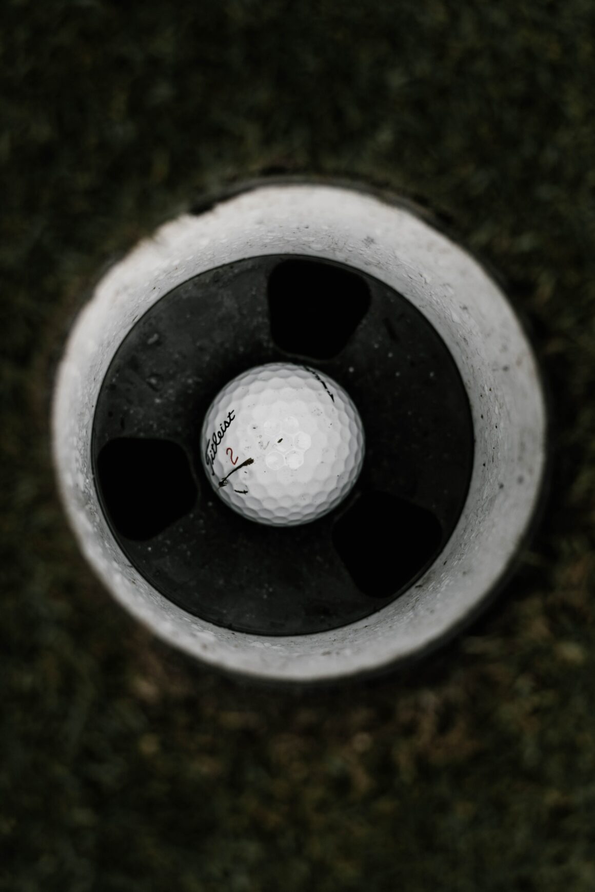 Golfball im Loch. Foto: Will Porada/ Unsplash