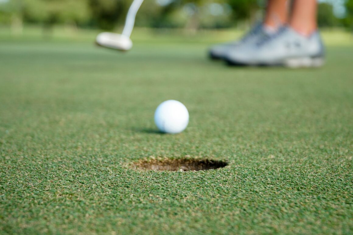Golfer beim Putten. Foto: Thomas Park/ Unsplash